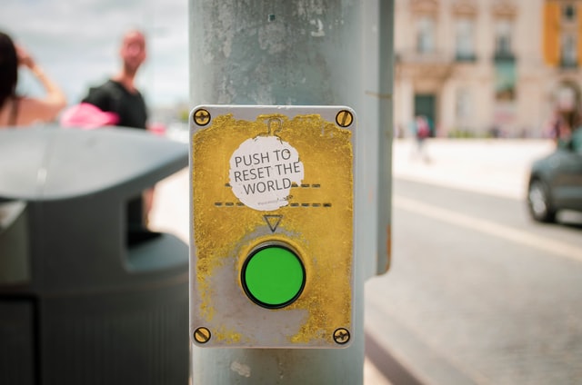 A sign saying 'push to reset the world' A sign saying 'push to reset the world'